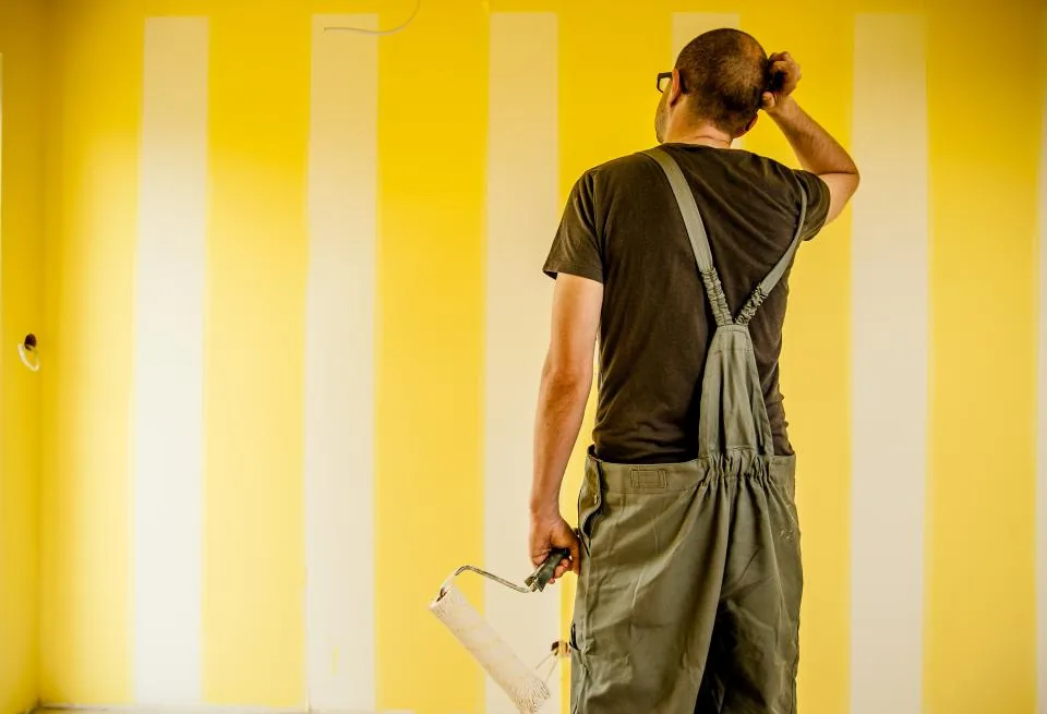 Painter checking the finish of a striped wall